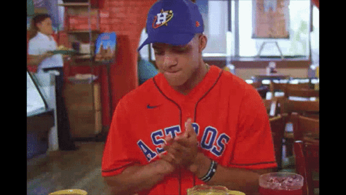 A Man Wearing A Red Astros Jersey And A Blue Hat GIF