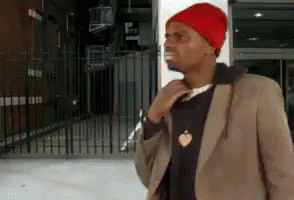 A Man Wearing A Red Beanie And A Brown Jacket GIF