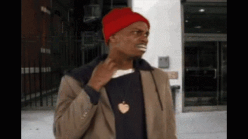 A Man Wearing A Red Beanie And A Necklace With An Apple Pendant GIF