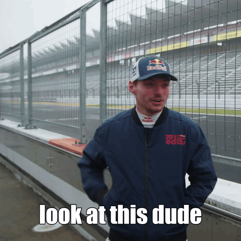 a man wearing a red bull hat and a blue jacket says " look at this dude "