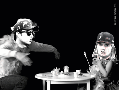 A Man Wearing A Red Bull Hat Sits At A Table GIF