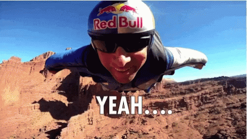 A Man Wearing A Red Bull Helmet And Sunglasses Is Flying Through The Air GIF