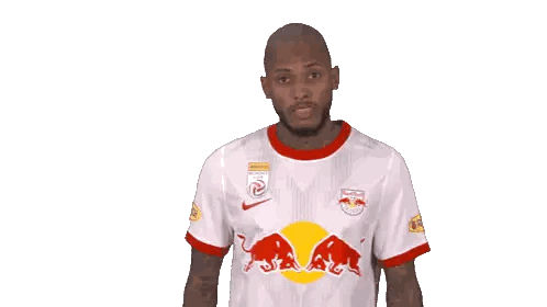 a man wearing a red bull shirt holds his finger to his mouth