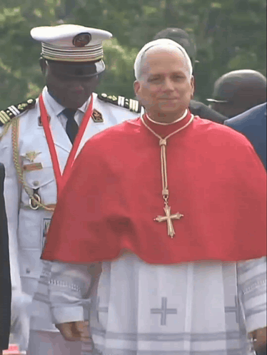 A Man Wearing A Red Cape With A Cross On It GIF