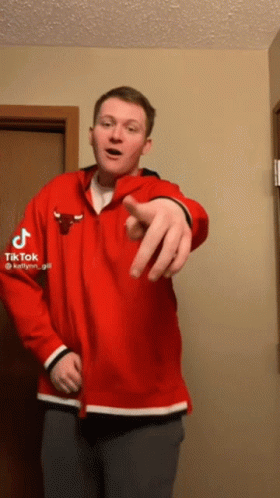 A Man Wearing A Red Chicago Bulls Jacket Points At The Camera GIF