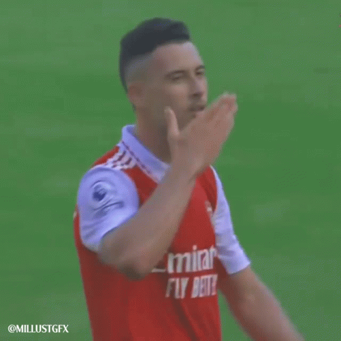 a man wearing a red emirates fly better jersey