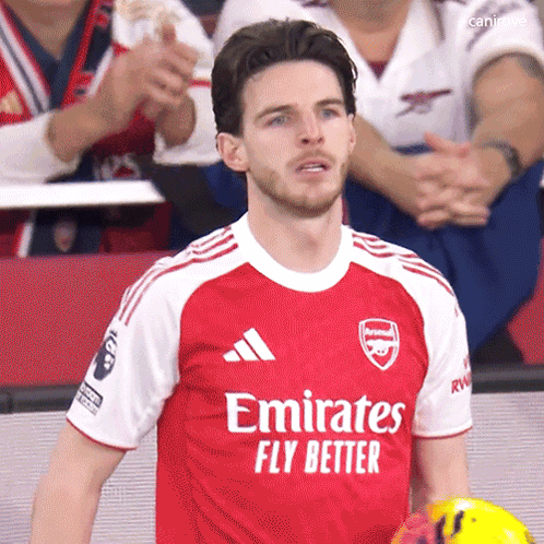 A Man Wearing A Red Emirates Fly Better Jersey Holds A Soccer Ball GIF