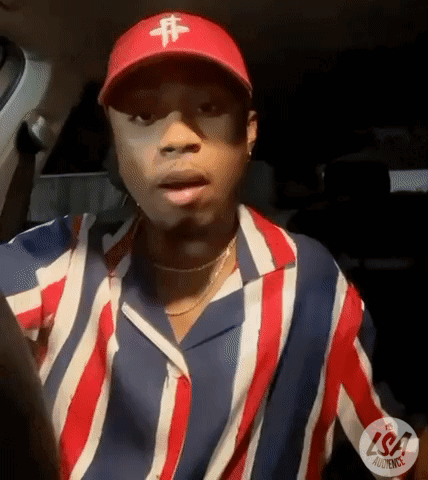 A Man Wearing A Red Hat And A Striped Shirt Is Sitting In A Car . GIF