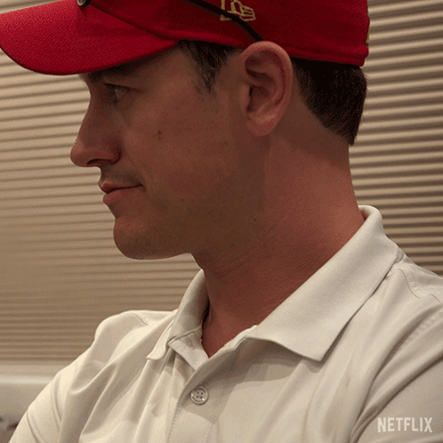 A Man Wearing A Red Hat And A White Shirt With Netflix On The Bottom GIF