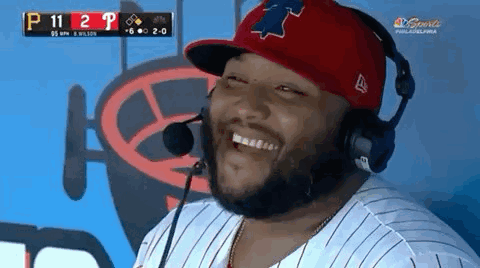 A Man Wearing A Red Hat And Headphones Is Laughing GIF