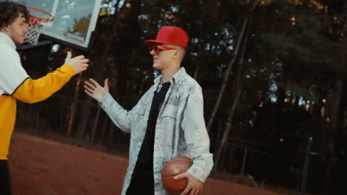 A Man Wearing A Red Hat And Sunglasses Is Holding A Spalding Basketball GIF