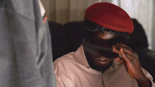 A Man Wearing A Red Hat Is Covering His Face With His Hands GIF