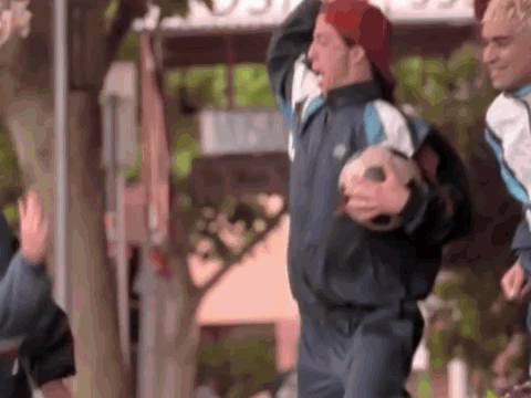 A Man Wearing A Red Hat Is Holding A Soccer Ball In His Hands . GIF