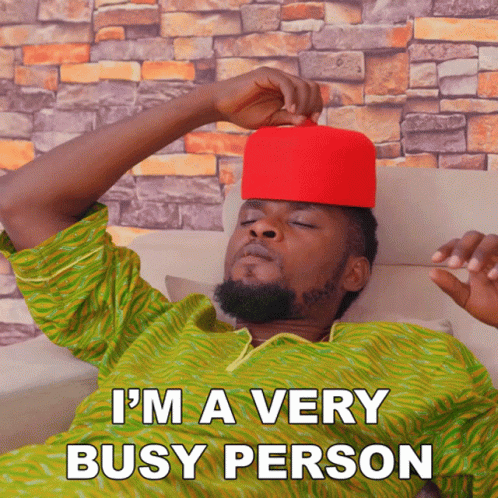 A Man Wearing A Red Hat Is Laying On A Couch With The Words I 'M A Very Busy Person Above Him GIF