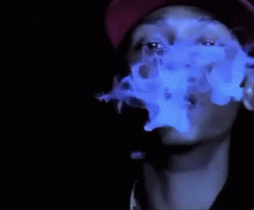 A Man Wearing A Red Hat Is Smoking A Cigarette With Blue Smoke Coming Out Of His Mouth . GIF