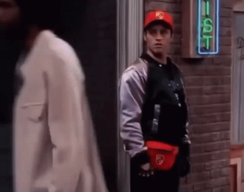 A Man Wearing A Red Hat Is Standing In Front Of A Sign That Says Gst GIF