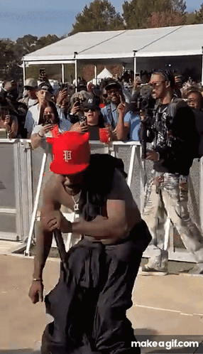 a man wearing a red hat with the letter f on it is dancing in front of a crowd