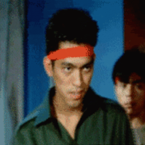 a man wearing a red headband is looking at the camera
