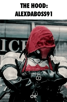 A Man Wearing A Red Hood Is Standing In Front Of A Building . GIF
