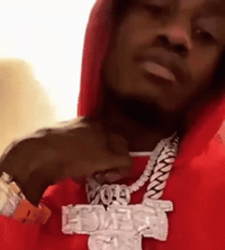 A Man Wearing A Red Hoodie And A Necklace With A Cross On It GIF
