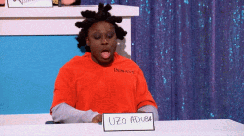 A Man Wearing A Red Inmate Shirt Is Sitting At A Table GIF