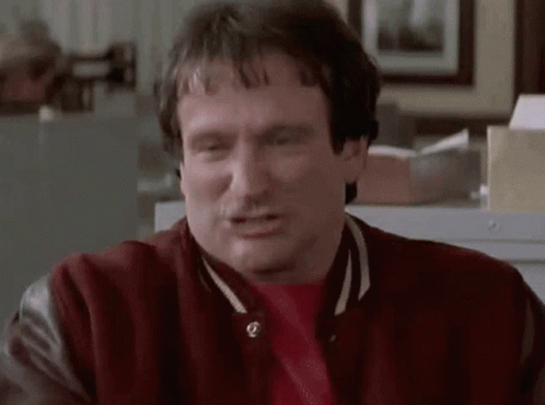 A Man Wearing A Red Jacket And A Red Shirt Is Making A Face . GIF