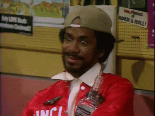 A Man Wearing A Red Jacket That Says ' Inc ' On It Is Holding A Bottle GIF