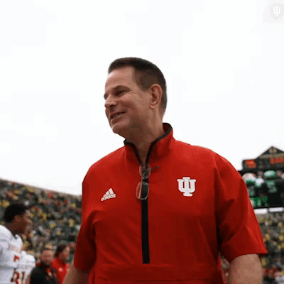 A Man Wearing A Red Jacket With The Letter I On The Front GIF