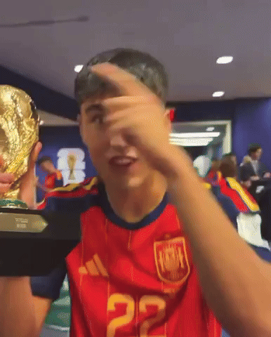 a man wearing a red jersey with the number 22 on it holds a trophy