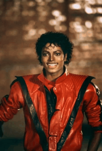 A Man Wearing A Red Leather Jacket Is Smiling GIF