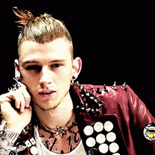 A Man Wearing A Red Leather Jacket With Spikes On It Talks On A Cell Phone GIF