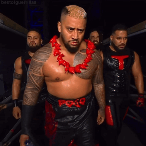 A Man Wearing A Red Necklace With A T On It GIF