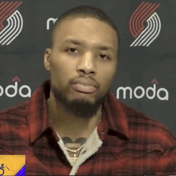 A Man Wearing A Red Plaid Shirt Is Standing In Front Of A Moda Sign GIF