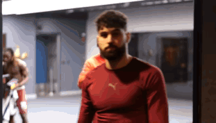 A Man Wearing A Red Puma Shirt Stands In A Gym GIF
