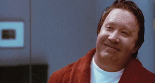 A Man Wearing A Red Robe And A White Shirt Is Smiling GIF