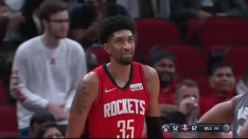 A Man Wearing A Red Rockets Jersey Stands In Front Of A Crowd GIF