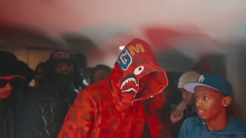 A Man Wearing A Red Shark Hoodie With Gm Written On It GIF