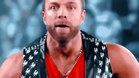 A Man Wearing A Red Shirt And A Black Vest With La Letters On It GIF