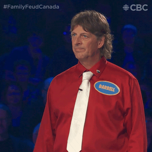 A Man Wearing A Red Shirt And Tie Has A Name Tag That Says Darrell GIF