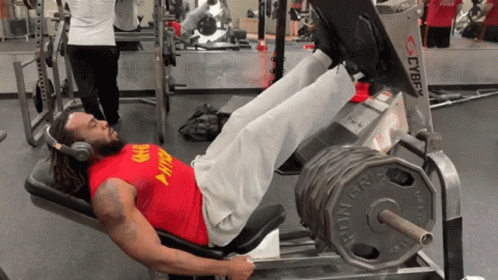 A Man Wearing A Red Shirt That Says Army On It Is Doing Leg Presses GIF