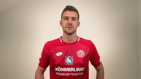 A Man Wearing A Red Shirt That Says Kommerling Premium Fenster On It GIF