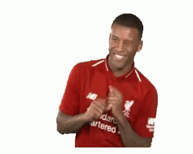 A Man Wearing A Red Shirt That Says Standard Chartered On It Is Smiling . GIF