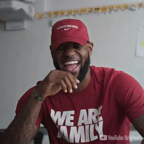 A Man Wearing A Red Shirt That Says We Are Family Is Laughing GIF