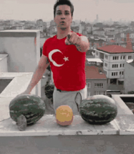 A Man Wearing A Red Shirt With A Crescent Moon And Star On It GIF