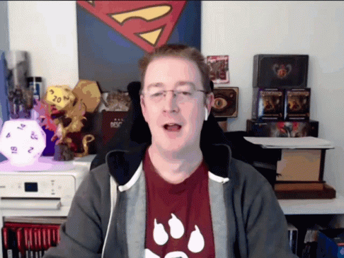 Man In Red Shirt With Paw Prints In Front Of Superman Painting GIF