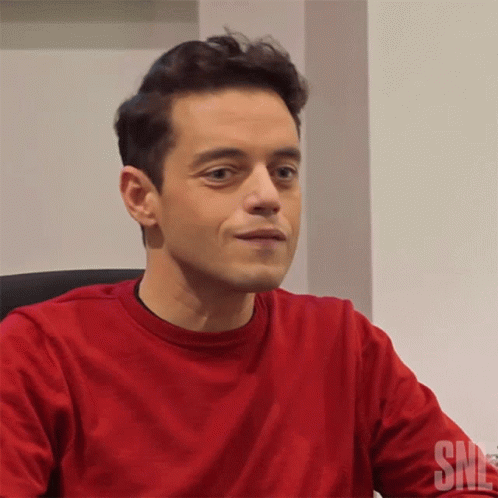 A Man Wearing A Red Shirt With The Word Snl On The Bottom GIF