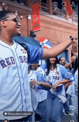 A Man Wearing A Red Sox Jersey Stands In Front Of A Crowd GIF