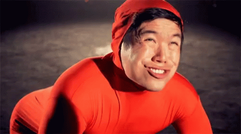 A Man Wearing A Red Suit And A Red Hat Smiles For The Camera GIF