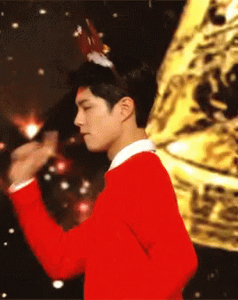 A Man Wearing A Red Sweater And A Reindeer Headband GIF