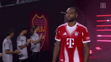 a man wearing a red t-mobile jersey stands in front of a sign that says abj